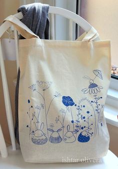 a bag sitting on top of a white chair next to a wooden window sill