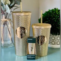 two gold candles sitting next to each other on a table