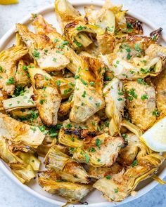 a white bowl filled with chicken and artichokes