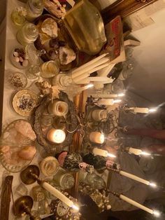 a table topped with lots of candles and dishes