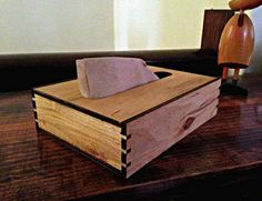 a tissue dispenser sitting on top of a wooden box