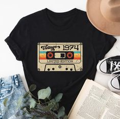 a black shirt with the words best of 1989 printed on it next to an open book