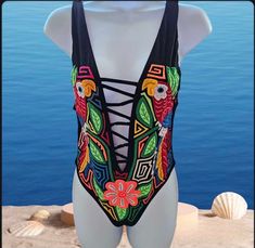 One piece swimsuit. This unique piece is made with authentic mola by indigenous women from Guna Yala Panama. Note: For sanitary reasons, swimsuits cannot be changed or returned. Please check the sizes before purchasing. (85% Nylon, 15% spandex, hand wash) Approximate measurements: Size M Bust: 29" Waist: 28" Hip: 30" Suit length: 26.5" --------------------- Approximate measurements: Sizes Bust: 30" Waist: 28" Hip: 30" Suit length: 25.5" One-piece Swimwear For Beach Festival, One-piece Swimwear For Summer Festival, Bohemian Fitted Swimwear For Festival, Bohemian Fitted Festival Swimwear, Bohemian Sleeveless Swimwear For Festivals, Sleeveless Swimwear For Beach Festivals, Bohemian Sleeveless Swimwear For Swimming, Bohemian One-piece Swimwear For Festival, Multicolor One-piece Swimwear For Festival