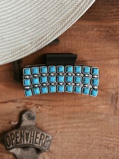 a close up of a metal object on a wooden surface with a hat and other items