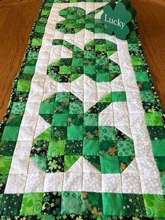 a quilted table runner with shamrocks on it and the name lucky written in green