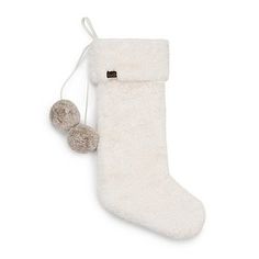 a white stocking with two pom poms hanging from it's side