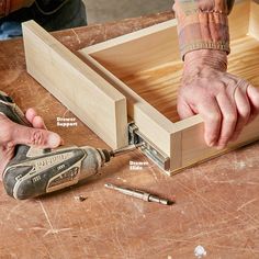 a person using a drill to attach the bottom part of a wooden box with screwdrivers