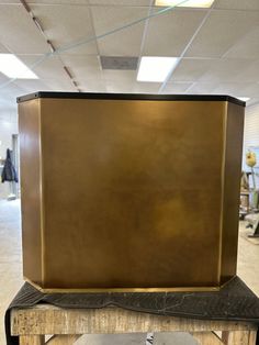 a large metal box sitting on top of a wooden table in an office building,