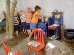 children are playing with toys in an outdoor play area that looks like a sandbox