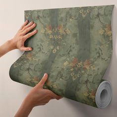 two hands holding onto a green floral wallpaper