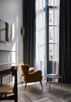 a chair sitting in front of a window next to a table