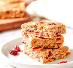 three granola bars stacked on top of each other with cranberry toppings