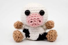 a crocheted stuffed animal sitting on top of a white surface with black eyes