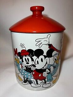 a red and white mickey mouse canister with an image of the characters on it