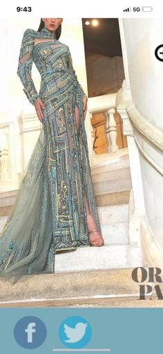 a woman in a long dress standing on some steps with her hands on her hips