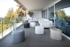 an outdoor living area with white furniture and large windows