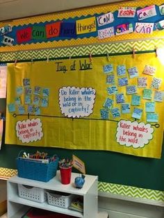 a bulletin board with writing on it in a classroom setting that is decorated with yellow, blue and green