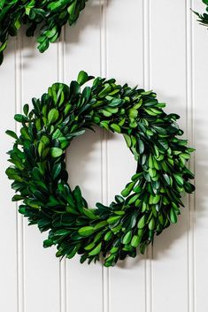 two green wreaths hanging on the wall