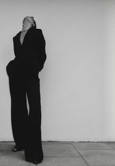 black and white photograph of a woman leaning against a wall