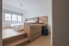 a bed sitting on top of a wooden step next to a window in a bedroom