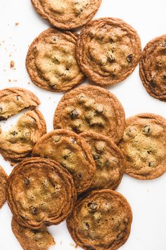 chocolate chip cookies on a white surface with crumbs all over the top and bottom