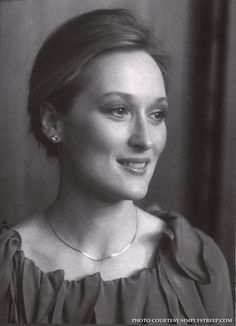 a black and white photo of a woman smiling