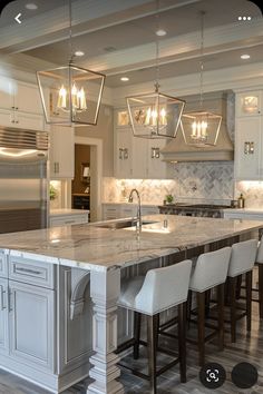 a large kitchen with an island in the middle and four chairs at the counter top