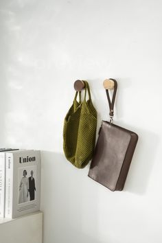 a purse hanging on the wall next to a book