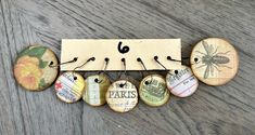 a bunch of buttons that are sitting on a wooden board with clothes pins attached to them