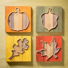 four pieces of wood that have been carved into the shape of leaves and pumpkins