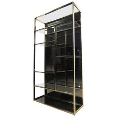 a black and gold bookcase with glass shelves on each side, against a white background