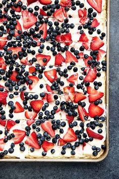 an uncooked dessert with strawberries and blueberries on top is ready to be eaten