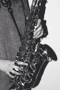 a black and white photo of a woman holding a saxophone