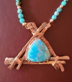 Handmade Turquoise and copper pendant with beaded necklace. Copper strips have been hand fired to bring out the beautiful natural patina of the copper.  A gorgous bezeled  piece of Turquoise with copper veins running through it nestles upon the copper frame. It is in the shape of  triangle reminiscent of a tepee. The necklace itself is beaded with fauceted Turquoise and copper beads. It is 19 inches long, 21 inches with the pendant. It fastens with a copper toggle  Very easy to take on and off. Handmade Artisan Turquoise Necklace For Healing, Handmade Rustic Turquoise Necklace, Rustic Turquoise Necklace For Gift, Handmade Rustic Blue Turquoise Necklace, Artisan Chrysocolla Turquoise Necklace For Jewelry Making, Rustic Handmade Blue Turquoise Necklace, Blue Bohemian Hand Forged Necklace, Handmade Copper Turquoise Necklace As Gift, Rustic Blue Handmade Necklace