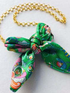 An Elegant Statement Gold Plated Necklace with a Silk Bow featuring Liberty print. Bold and colourful, this piece is uniquely designed to celebrate individuality. Elevate your look with this stunning accessory.  Each necklace is designed and handmade by myself in my Dartmoor Devon studio, UK. Material  Gold plated necklace with a 100% silk Liberty print bow. Chain: Rolo style gold plated chain. Closure: Secure lobster clasp for easy wearing. Available in 5 beautiful Liberty print options (please Green Chain Necklace Gift, Green Chain Necklace As Gift, Green Chain Necklace For Gift, Chic Multicolor Jewelry For Gifts, Chic Green Jewelry For Gifts, Bow Necklace, Liberty Print, Black Jewelry, Rolo Chain