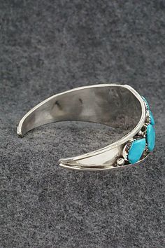 This turquoise and sterling silver bracelet was made by Zuni silversmith Vangie Tsabetsaye. The inside is signed Tsabetsaye and sterling.Size: 5 1/4" (will fit up to a 6 1/2" wrist)Gap: 1 1/4"Width: 1" tapered to 1/8"Free shipping on all orders! We ship with USPS and always include tracking. All orders ship within a day of payment.Returns are accepted up to 30 days after you receive your order. Just send us a message. Our shop offers cash back or store credit. The item must be returned in new co Traditional Turquoise Sterling Silver Cuff Bracelet, Turquoise Sterling Silver Cuff Bracelet With Inlay, Sterling Silver Turquoise Cuff Bracelet With Inlay, Adjustable Turquoise Bracelet With Polished Finish, Adjustable Turquoise Bracelets With Polished Finish, Adjustable Turquoise Bracelet With Inlay, Adjustable Turquoise Inlay Bracelets, Holiday Sales, Sterling Silver Bracelet