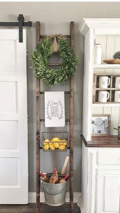 an old wooden ladder is used as a shelf for fruit and vegetables in the kitchen