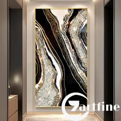 an abstract painting in black and white with gold accents on the wall next to a cabinet