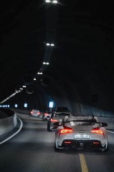 two sports cars driving through a tunnel at night