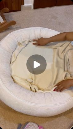 a woman laying on top of a white round bed