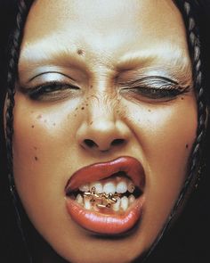 a close up of a woman with her mouth open and piercings on it's teeth