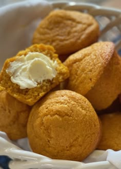 a white basket filled with muffins covered in cream