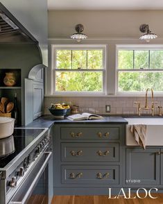 a kitchen with gray cabinets and wood floors