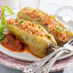 two stuffed hot dogs on a plate with ketchup