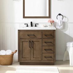 a bathroom with a sink, mirror and toilet paper roll on the floor next to it