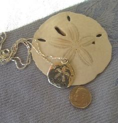 Timeless sterling silver diamond cut necklace with a medium to large-sized (please see pictures with dime) sand dollar charm attached to a sterling 16 inch chain. This is not huge but big enough to make a statement and great for everyday wear. Represents beautiful legend of the sand dollar. Please select 16 or 18 inch chain before adding to cart. Simple but elegant and perfect for any time. Silver Engraved Necklace For Beach, Beach Pendant Jewelry With Engraving, Engraved Pendant Necklace For Beach, Beach Engraved Pendant Jewelry, Silver Coastal Jewelry For Beach, Coastal Style Silver Jewelry For Beach, Silver Coastal Jewelry Gift, Coastal Style Silver Jewelry For Gifts, Coastal Style Silver Jewelry Gift