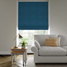 a living room with a white couch and blue roller shades