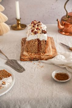 a piece of cake sitting on top of a wooden cutting board next to two plates