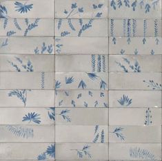 blue and white ceramic tiles with flowers and leaves painted on the backs of each tile