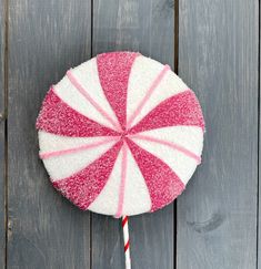 a pink and white lollipop sitting on top of a wooden table